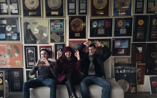 Christian Rodwell, right, with colleagues in front of the Cr2 Records gold disc wall