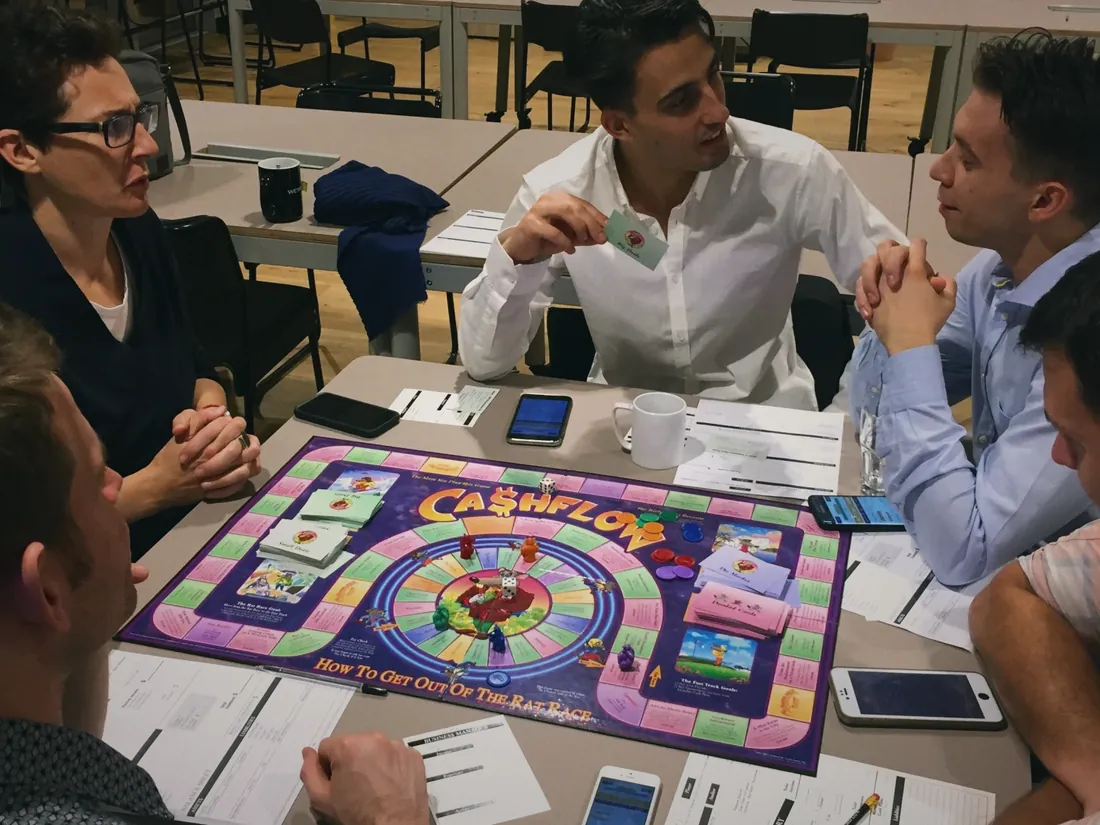Players around a Cashflow board game in London