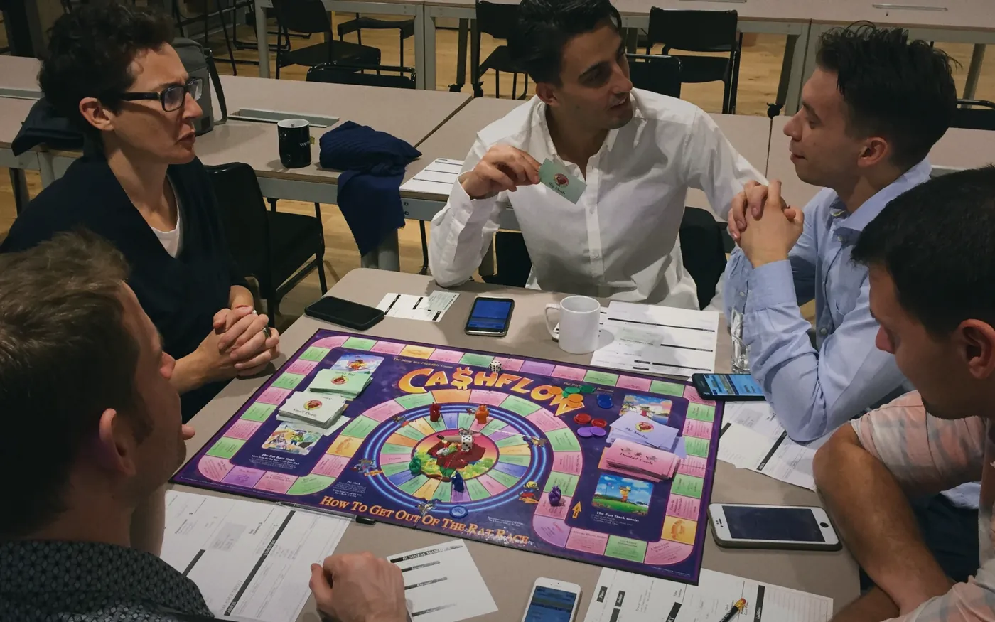 Players around a Cashflow board game at a London game night